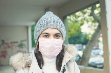 Sokakta maske takan genç bir kadın. 
