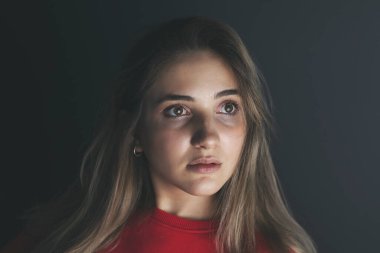 Karanlık arka planda genç bir kızın portresi..