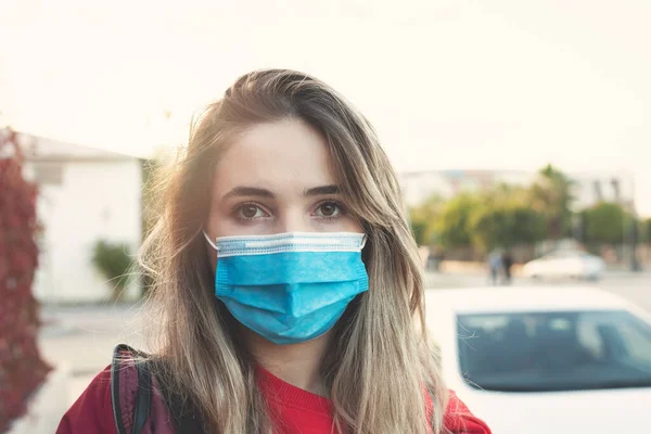 Sokakta maske takan genç bir kadın.