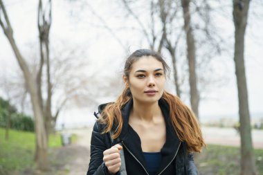 Genç, gülümseyen, çekici bir sporcu. Sabahları parkta koşuyor..