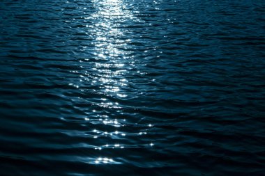 Geceleyin suyun üzerindeki ışığın yansıması.