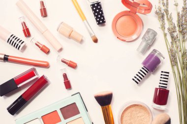 Beyaz arka planda farklı lüks makyaj ürünleri, üst görünüm