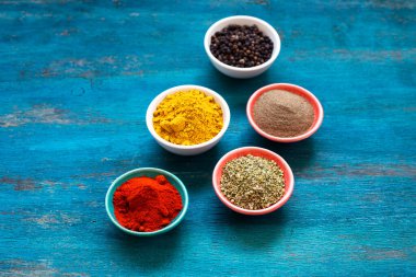 Mavi arka planda yemek pişirmek için çeşitli rengarenk sebzeler ve baharatlar