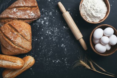 Fırın - siyah karatahta zemin üzerinde altın ekmek ve un somunları. 