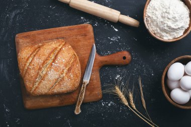 Fırın - siyah karatahta zemin üzerinde altın ekmek ve un somunları. 