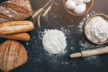 Fırın - siyah karatahta zemin üzerinde altın ekmek ve un somunları. 