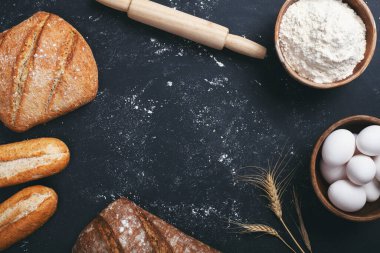 Fırın - siyah karatahta zemin üzerinde altın ekmek ve un somunları. 