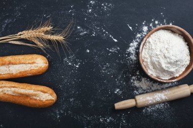 Fırın - siyah karatahta zemin üzerinde altın ekmek ve un somunları. 