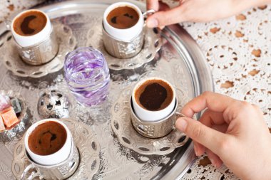 Group of people on the hands drinking turkish coffey, top view