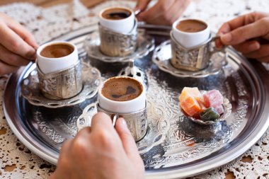 Group of people on the hands drinking turkish coffey, top view