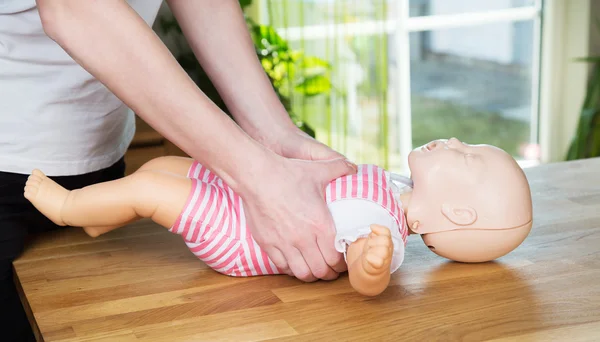 Bébé CPR compression à deux mains Image En Vente