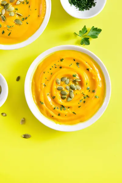 Pumpkin puree with seeds in bowl over yellow background with free text space. Healthy diet food concept. Top view, flat lay — Stock Image Pumpkin Puree Seeds Bowl Yellow Background Free Text Space Healthy Stock Image