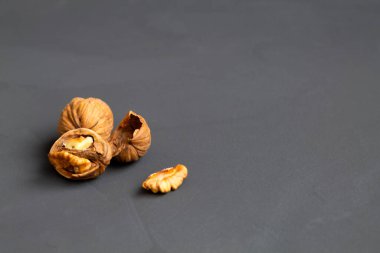 Kurutulmuş ceviz ve meyve. yakın plan kabuklu cevizler siyah bir masada ve cam bir kavanozda. Esmer fındıklar ve koyu bir arka plan. Boşluğu kopyala.