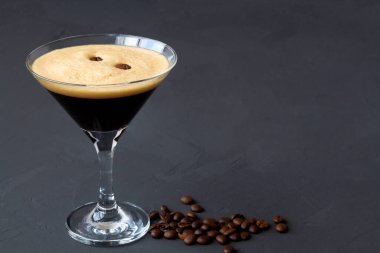 Kahve çekirdeğiyle süslenmiş espresso martini kokteyli. Siyah arka planda martini bardağı. Alkollü. kopyalama alanı. en üstteki görünüm