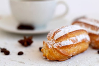 Beyaz arka planda bir tabakta yakın plan vanilya ekini. Kahve çekirdekli kahve fincanı ve anason yıldızı, beyaz masada tarçın çubukları. kopyalama alanı. Geleneksel Fransız Lezzetli Tatlı.