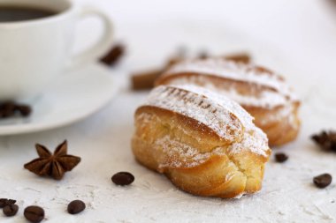 Beyaz arka planda bir tabakta yakın plan vanilya ekini. Kahve çekirdekli kahve fincanı ve anason yıldızı, beyaz arka planda tarçın çubukları. kopyalama alanı. Geleneksel Fransız Lezzetli Tatlı.
