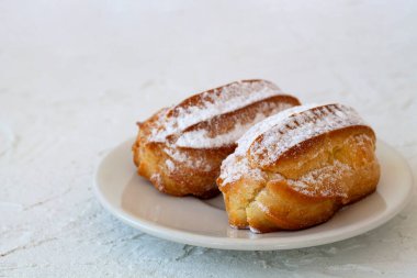 Beyaz arka planda bir tabakta vanilya ekini. Geleneksel Fransız tatlısı. Boşluğu kopyala