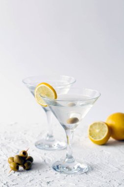 Barda margarita kokteyli. Yeşil naneli ve beyaz arka planda zeytinli iki martini bardağı. Alkollü. Zeytinli martini için bardaklar. kopyalama alanı. dikey