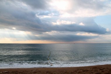 Sabah kumsalda. Akdeniz manzarası çok güzel. Sahilden denize. Sahilde güneş ışığı altında yürümek ve yeşil ağaçlarla mavi gökyüzü. Yaz manzaraları.