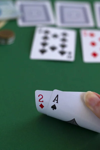 hand shows a cards two of diamond and spade ace in casino. playing cards with blue deck on the green table. combination of cards on a green casino desk background.copy space. vertical