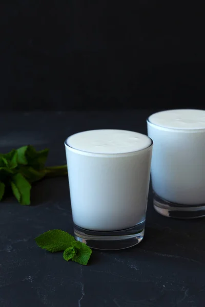 黑色背景的牛奶杯 加鲜绿色薄荷的白拉西酒 冷牛奶 印度菜 复制空间 酸奶与益生菌在黑暗的桌子上 健康的发酵产品概念 — 图库照片
