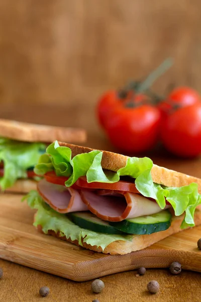 Cerrar Dos Sabrosos Sándwiches Con Jamón Ensalada Verde Pepinos Tomates — Foto de Stock