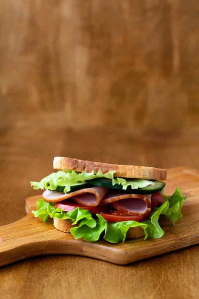 Sabroso Sándwich Con Jamón Ensalada Verde Pepino Tomates Fondo Madera — Foto de Stock