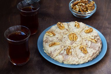 Türk mutfağı. Ayçiçeği halkası ve Türk çayı. Ahşap masanın üzerinde geleneksel bardakta. Yakın plan. Koyu kahverengi arka planda ceviz ve fotokopi alanı olan iki bardak siyah çay..