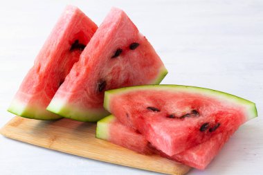 Bir dilim karpuz. Beyaz arka planda yakın plan olgun kırmızı karpuz. Tahtadaki taze karpuz. Masanın üzerinde fotokopi alanı var..