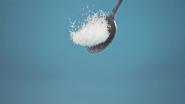 Super slow motion drop spoon with salt, on blue background. Filmed on a high-speed camera, 1000 fps. — Stock Video