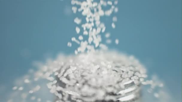 Szuper lassított felvételű sócsepp só egy sószórón a kéken. Nagy sebességű kamerával filmezve, 1000 fps. — Stock videók