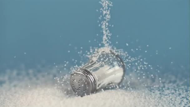 Супер повільний рух краплі солі на соляному шейкері на синьому. Знято на високошвидкісній камері, 1000 к/с . — стокове відео