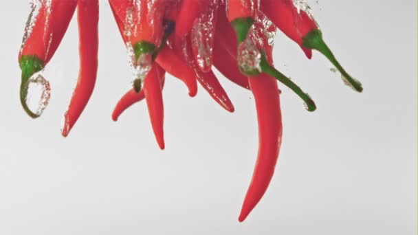 Super slow motion chili peper valt onder het water met luchtbellen. Gefilmd op een hoge snelheidscamera met 1000 fps. — Stockvideo