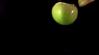 Çok yavaş çekim yapan taze elma parçaları suya dökülüyor. 1000 fps hızla yüksek hızda kamerayla çekiliyor..