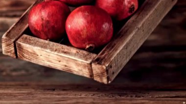 Süper yavaş çekim ahşap tepsi ve nar masaya düşer. 1000 fps hızla yüksek hızlı bir kamerayla çekildi..