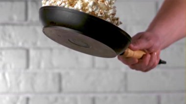 Çok yavaş çekimde adamın eli kızartma tavasıyla patlamış mısır fırlatıyor. 1000 fps hızla yüksek hızlı bir kamerayla çekildi..