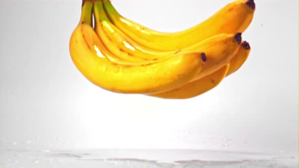 Super slow motion valt er een stel bananen op tafel. Gefilmd met 1000 fps. — Stockvideo