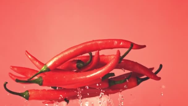Super zpomalené chilli lusky se zvedají s kapkami vody. Natočeno na vysokorychlostní kameře rychlostí 1000 snímků za sekundu. — Stock video