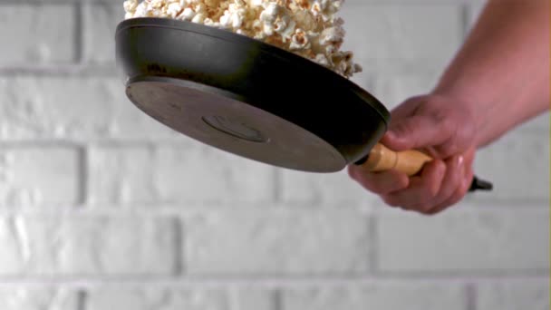 In Superzeitlupe wirft die Hand eines Mannes mit einer Pfanne Popcorn. Gefilmt mit einer Hochgeschwindigkeitskamera bei 1000 fps. — Stockvideo