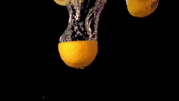 Des morceaux de citron au ralenti super tombent sous l'eau avec des bulles d'air. Filmé par une caméra haute vitesse à 1000 ips. — Video