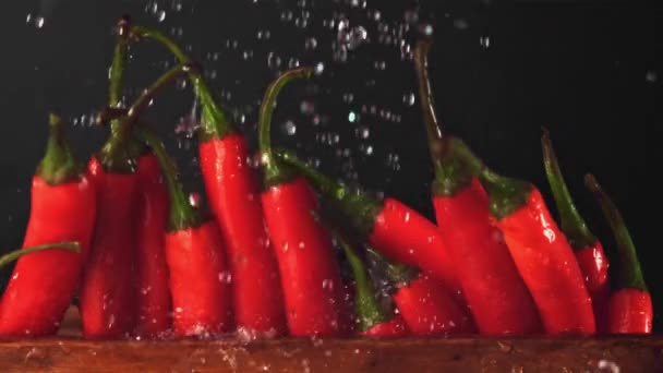 Super zpomalení na lusky červené chilli papričky v řadě kapky vody. Natočeno na vysokorychlostní kameře rychlostí 1000 snímků za sekundu. — Stock video