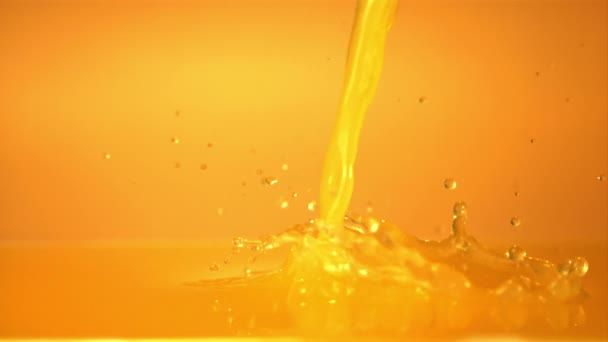 Super slow motion of the stream of orange juice pours with splashes. Filmed on a high-speed camera at 1000 fps. — Stock Video