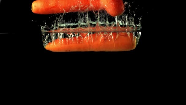 La zanahoria madura en cámara súper lenta cae bajo el agua con burbujas de aire. Filmado en una cámara de alta velocidad a 1000 fps. — Vídeo de stock