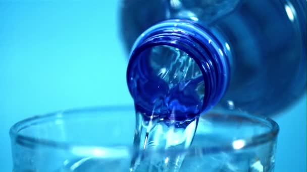 El agua en cámara súper lenta vierte de la botella al vidrio. Filmado en una cámara de alta velocidad a 1000 fps. — Vídeo de stock