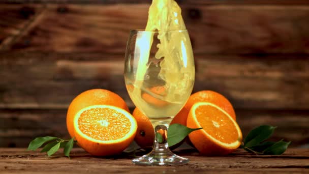 El jugo de naranja de cámara súper lenta se vierte en un vaso de spray. Filmado en una cámara de alta velocidad a 1000 fps. — Vídeos de Stock