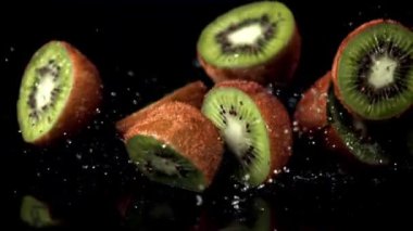 Süper yavaş çekimde kivi yarıları masaya düşer. 1000 fps hızla yüksek hızlı bir kamerayla çekildi..