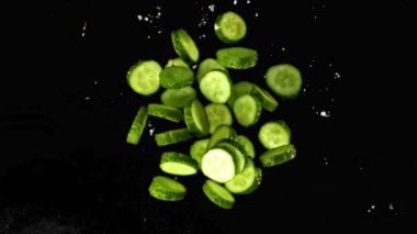 Süper yavaş çekimde dilimlenmiş salatalık ve su sıçraması. 1000 fps hızla yüksek hızlı bir kamerayla çekildi..
