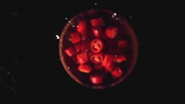 Super slow motion i pezzi di peperoncino in un piatto di legno con spruzzi d'acqua. Girato su una telecamera ad alta velocità a 1000 fps. — Video Stock