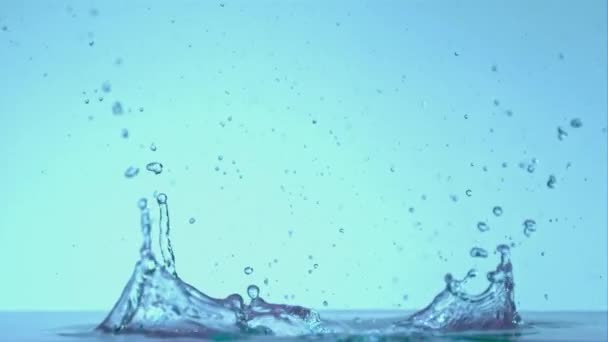 Super cámara lenta salpica agua en un fondo azul.Filmado en una cámara de alta velocidad a 1000 fps. — Vídeos de Stock