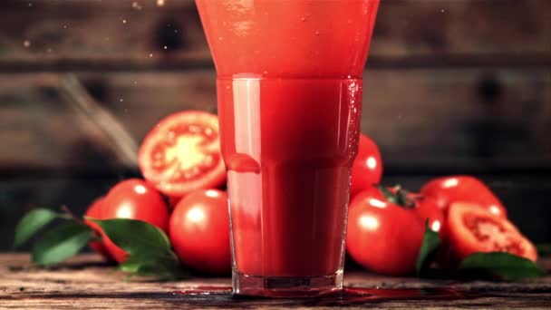 Movimento super lento em um copo com suco de tomate cai tomate com spray. Filmado em uma câmera de alta velocidade a 1000 fps. — Vídeo de Stock